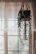Boho-style door curtain hanging gently in a sunlit room with plants.