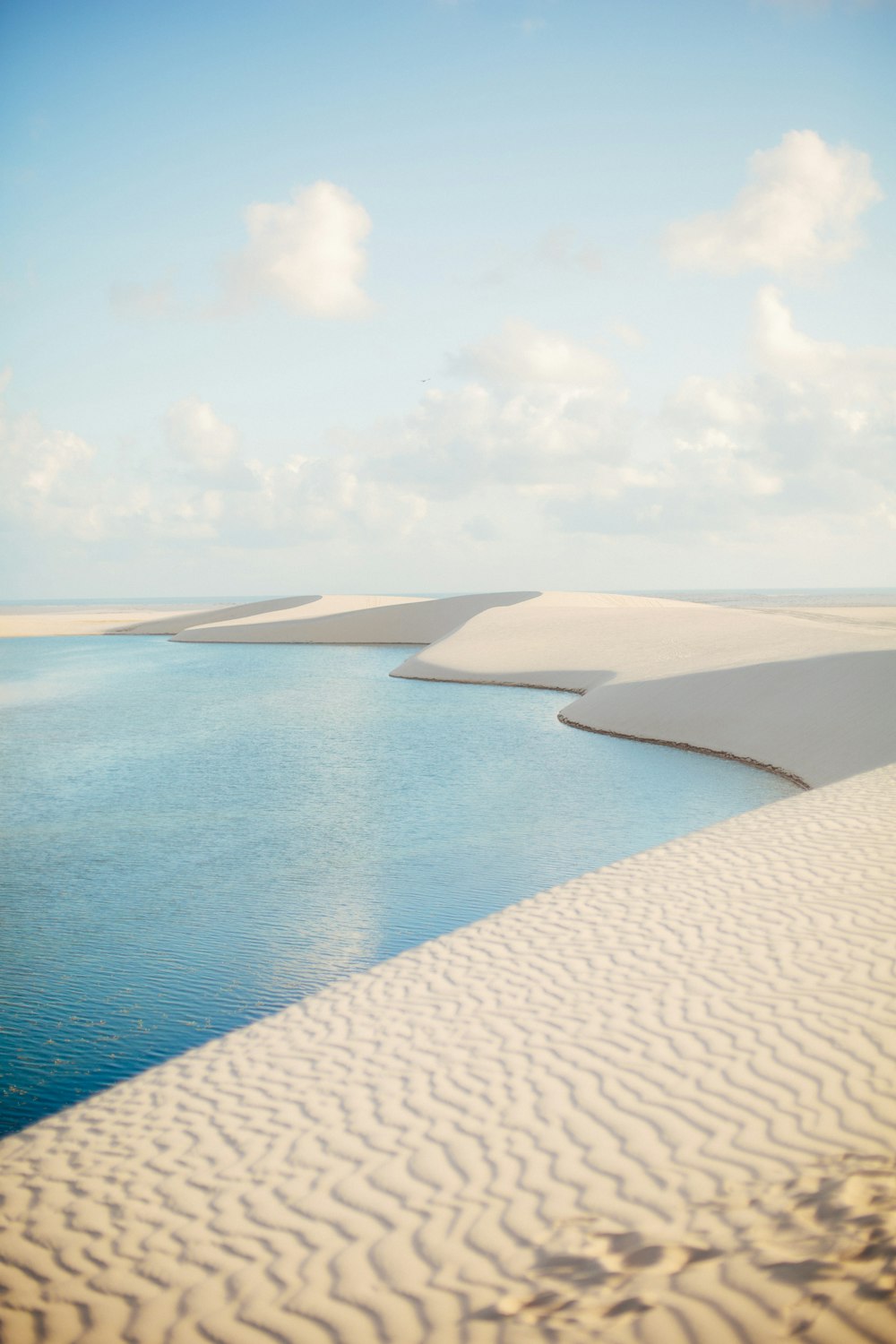 a body of water surrounded by sand dunes