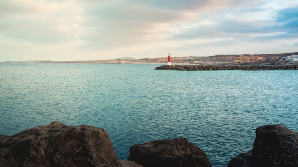 a body of water with a lighthouse in the distance