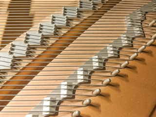 Technician voicing piano strings to balance tone quality.