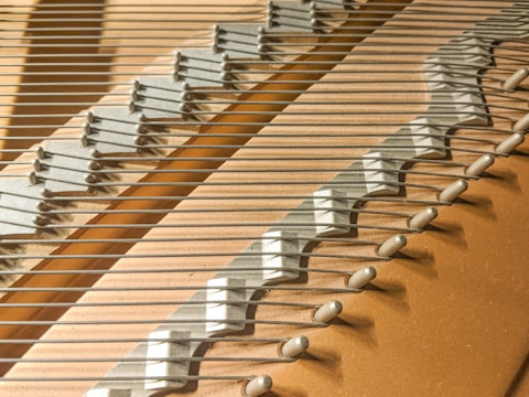 Technician voicing piano strings to balance tone quality.