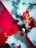 An abstract artwork featuring bold splashes of red, black, and white with hints of yellow and green. The composition includes sharp angles and blurred edges, with various overlapping textures that create a dynamic and chaotic visual effect.