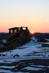 a bulldozer is sitting on top of a pile of snow