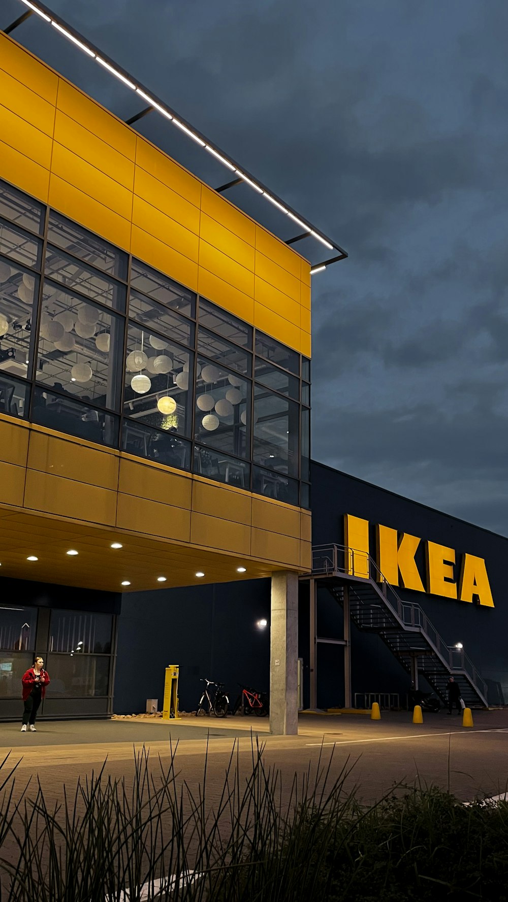 a yellow ikea store with a dark sky in the background