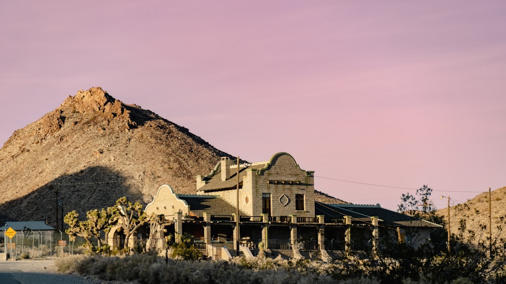 a large house with a mountain in the background