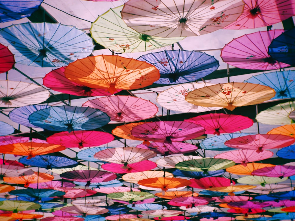 Un montón de paraguas de colores colgando del techo