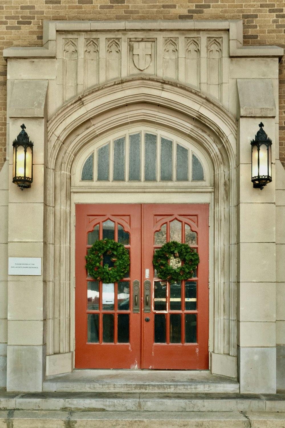 a red door with two wreaths on it