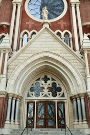 An ornate church entrance decorated with maroon and gold floral garlands.