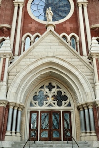 An ornate church entrance decorated with maroon and gold floral garlands.