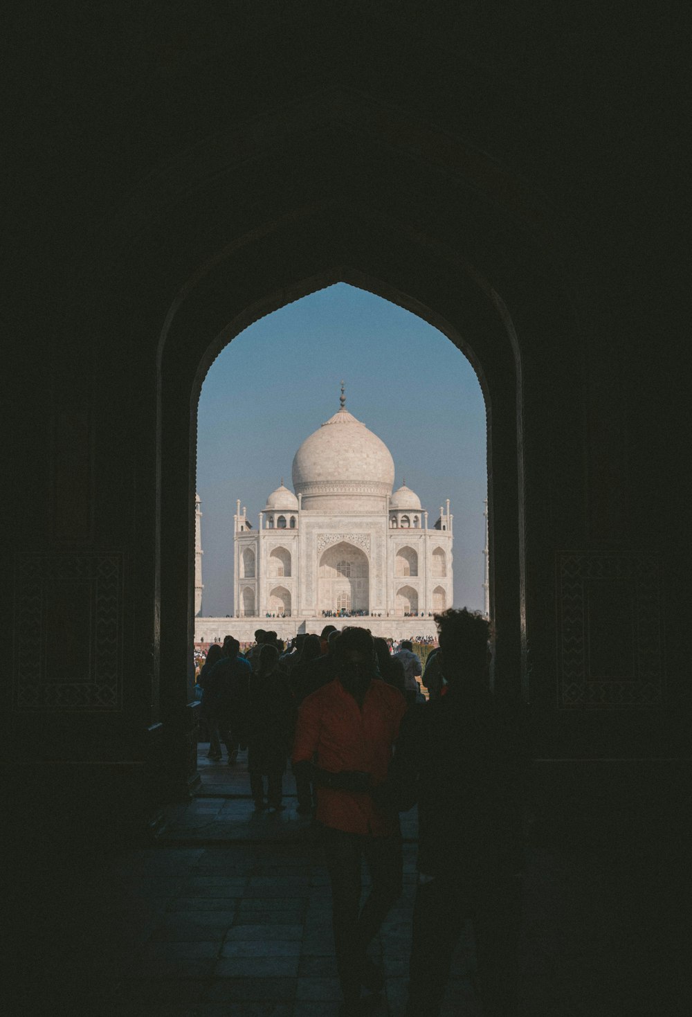 a group of people walking under an archway