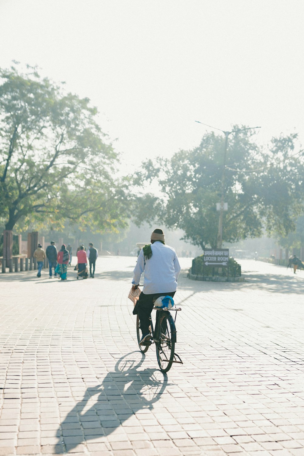 a man riding a bike down a brick road