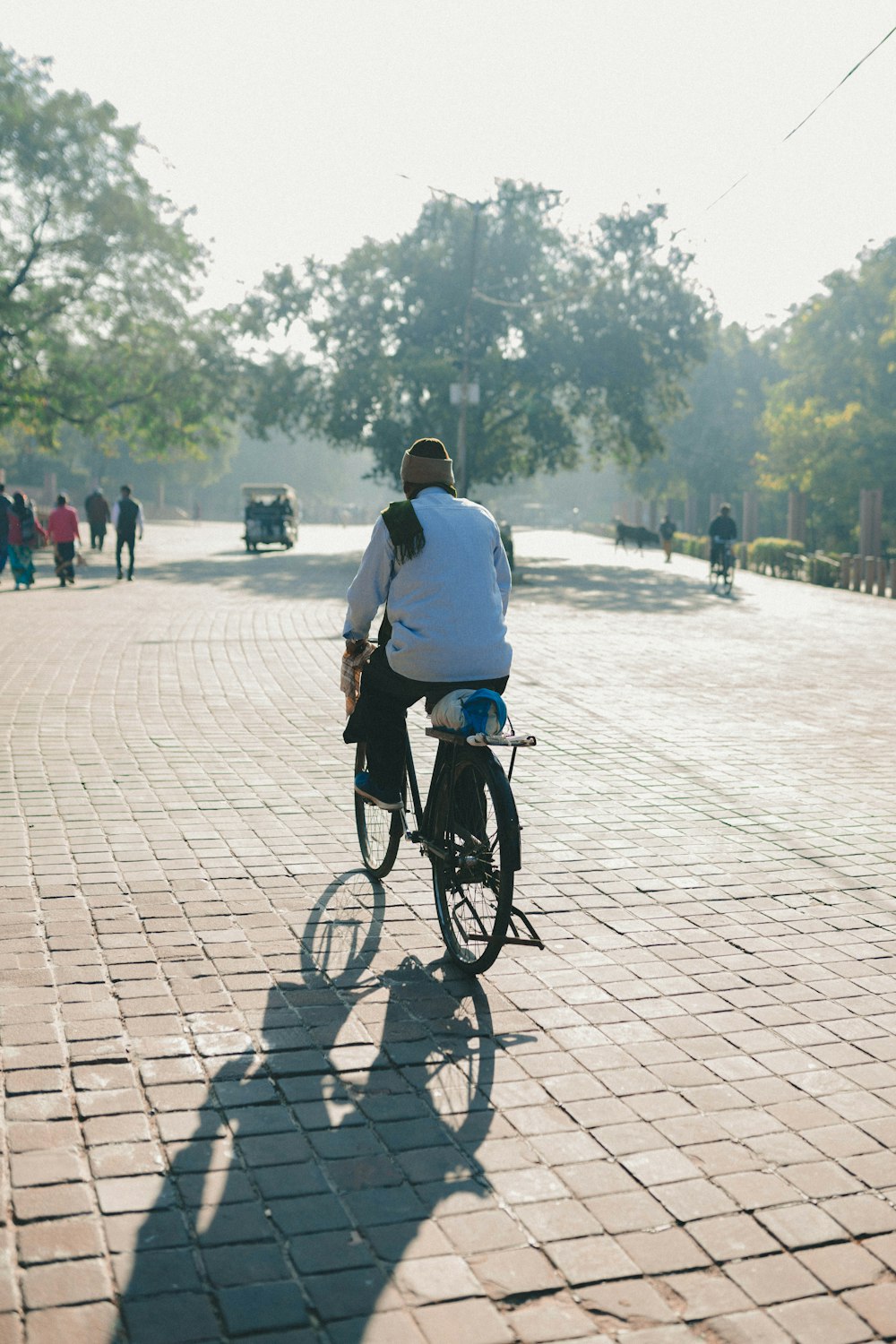 a man riding a bike down a brick road
