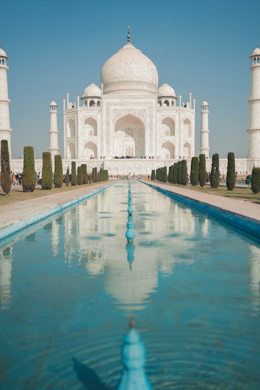 a large white building with a pool of water in front of it