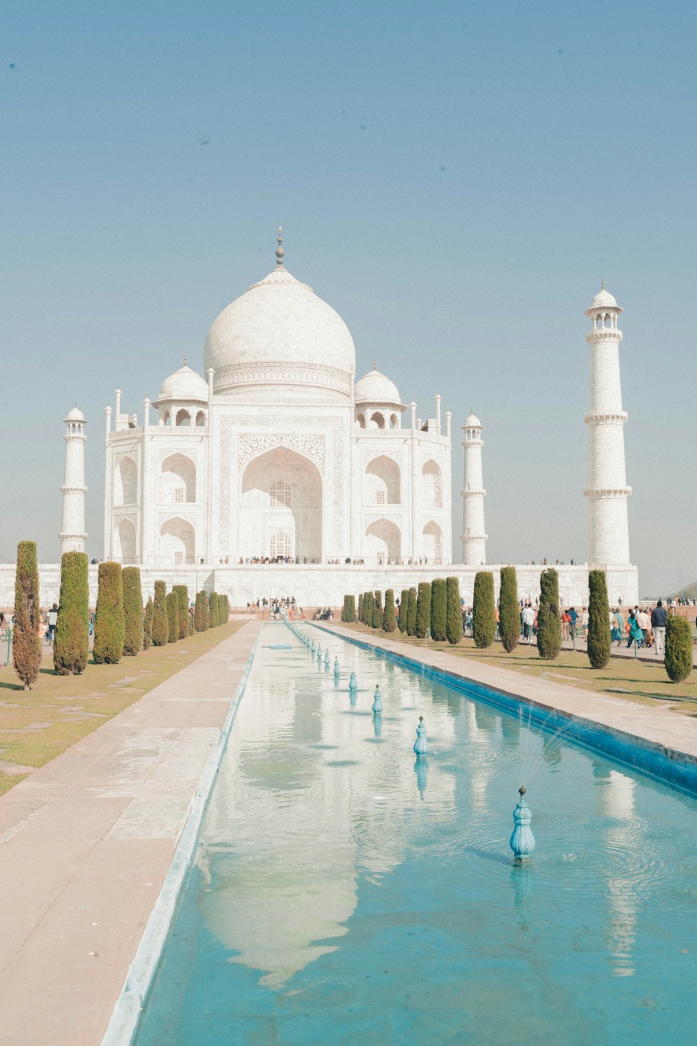 a large white building with a long pool of water in front of it