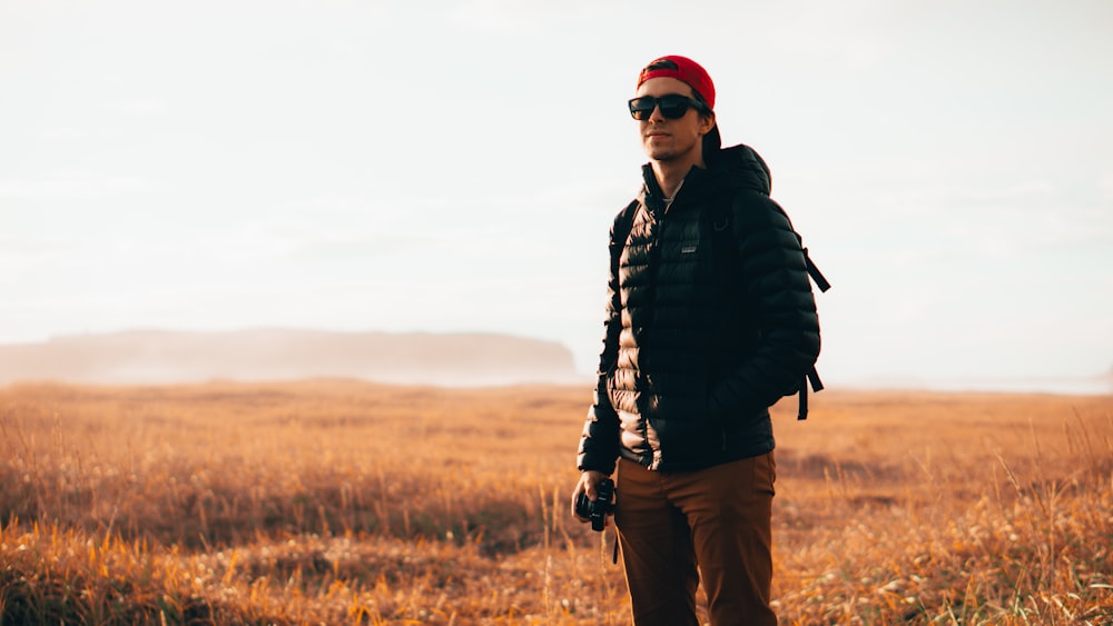 a man standing in a field with a camera