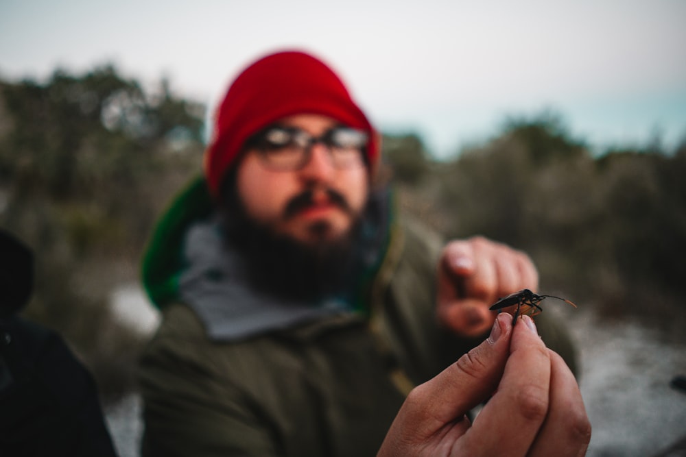 a man holding a small insect in his hand