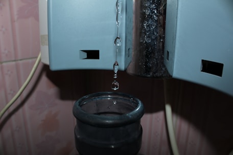 Close-up of a sleek, modern water dispenser with a glowing blue light.