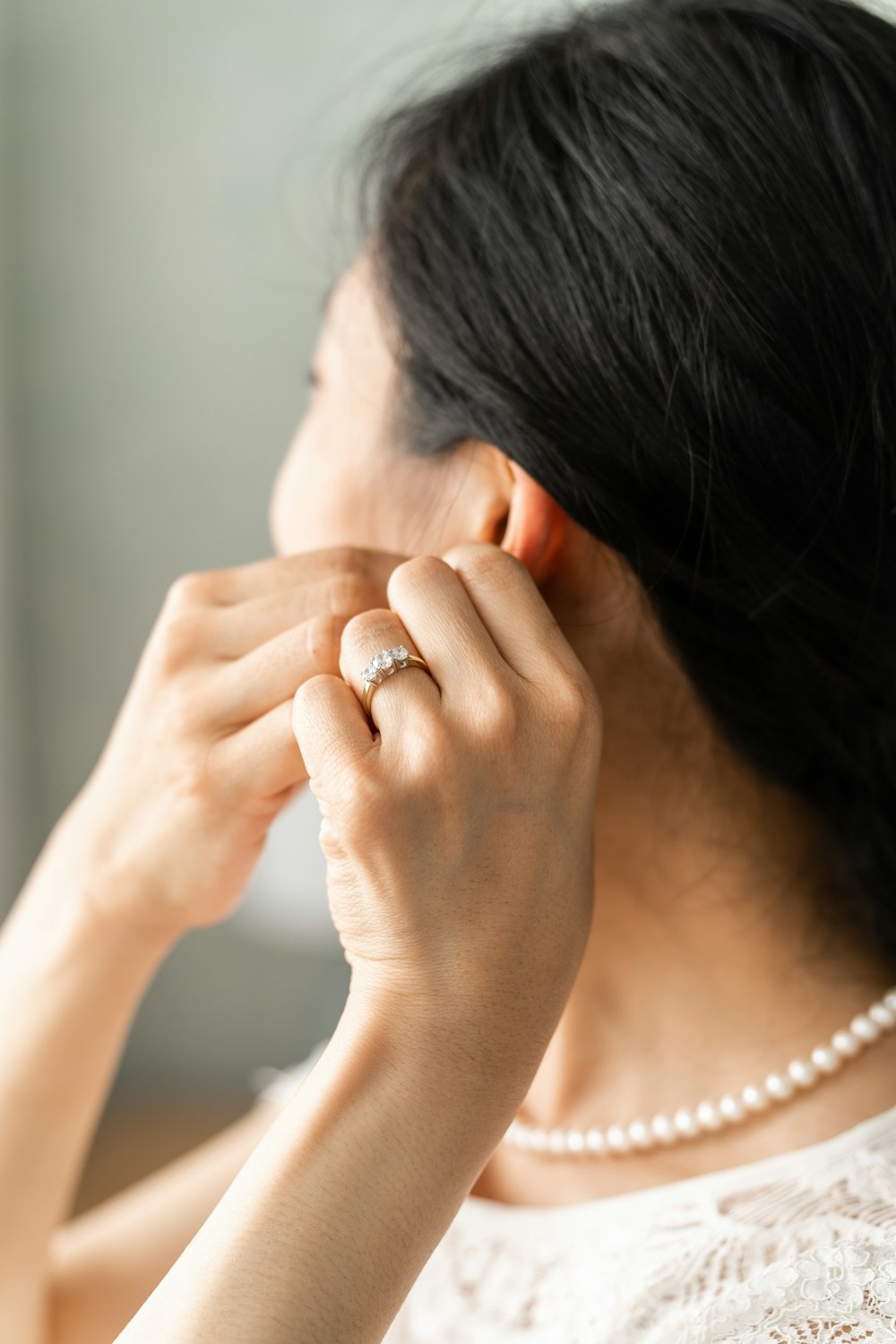 a woman putting a ring on her ear