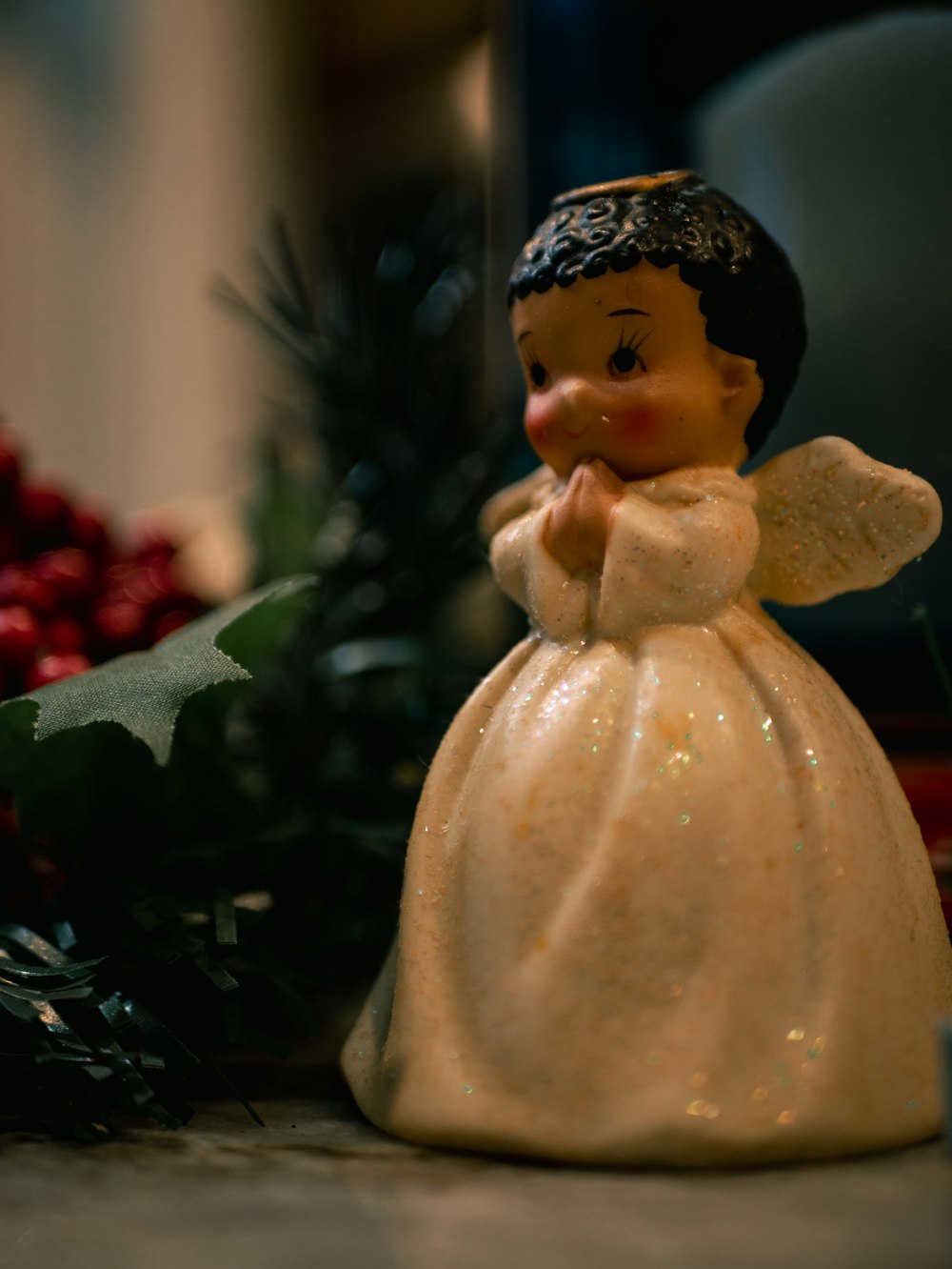 a little angel figurine sitting next to a christmas tree