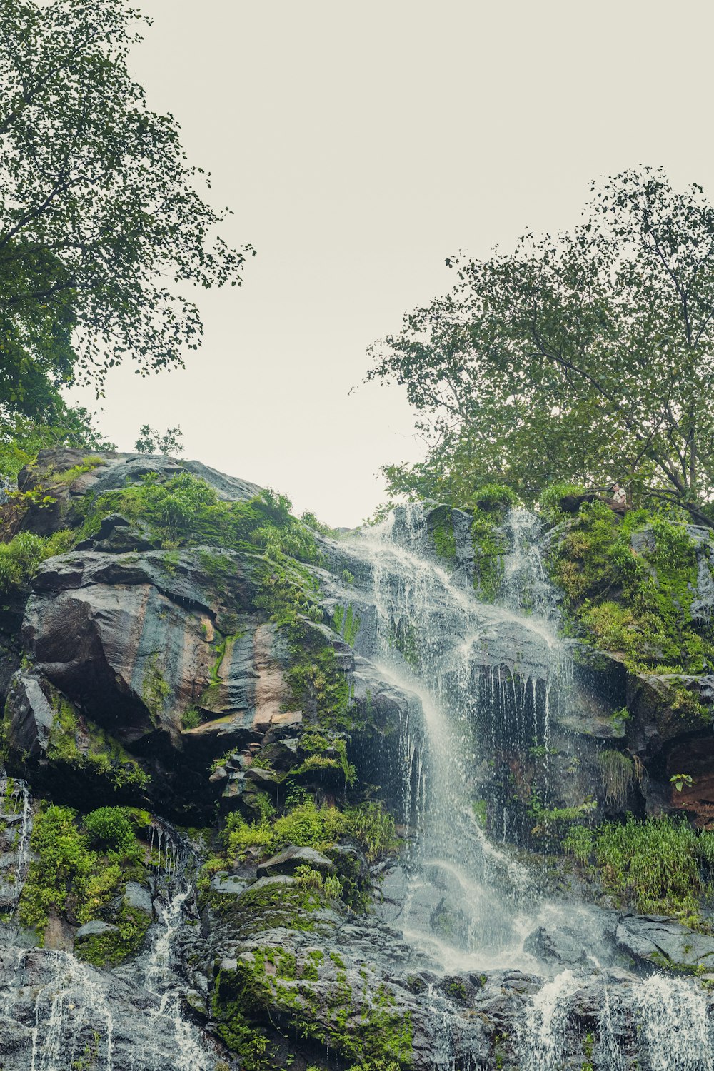 a couple of people standing in front of a waterfall