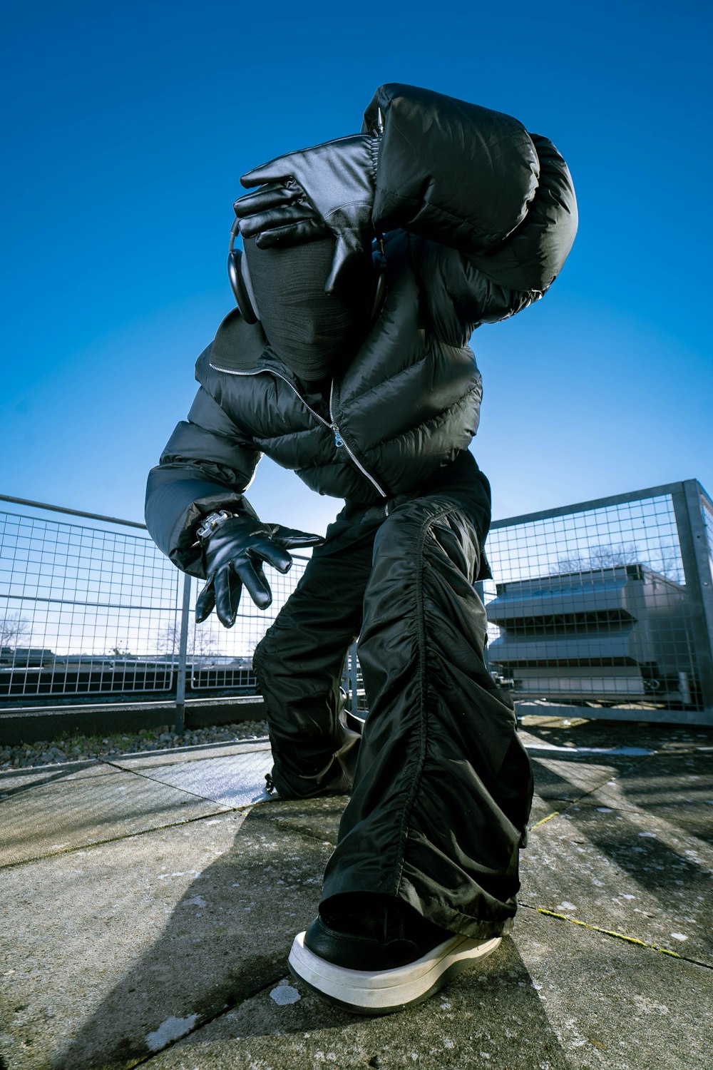 a skateboarder in a black jacket doing a trick