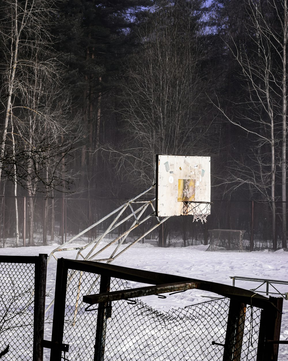 a basketball hoop in the middle of a snowy field