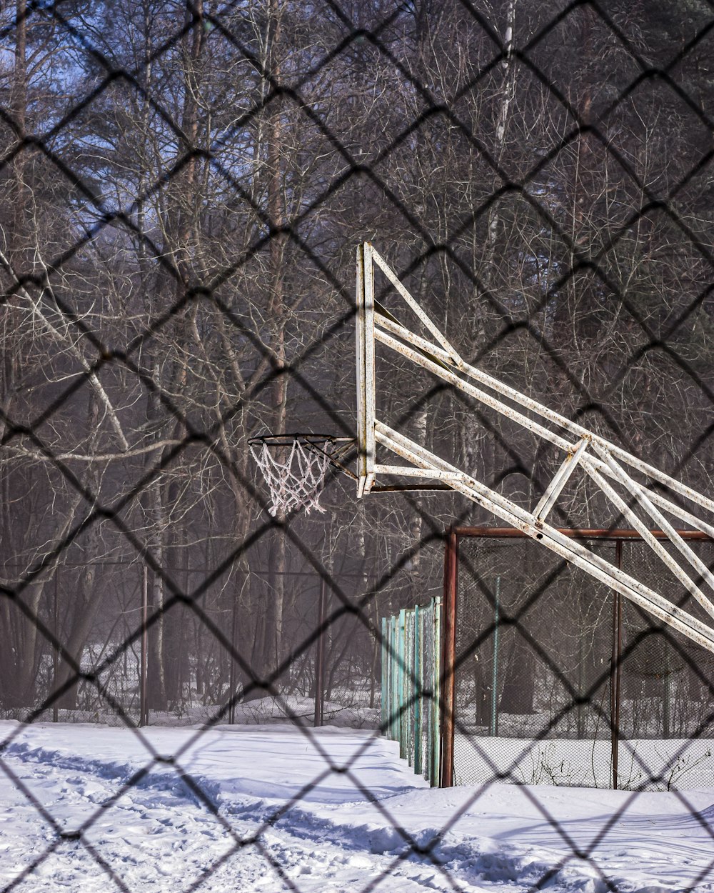 a basketball hoop in the middle of a snowy field