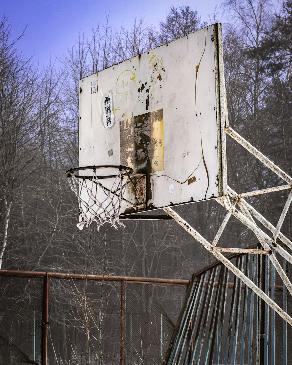 an old basketball hoop with a broken backboard