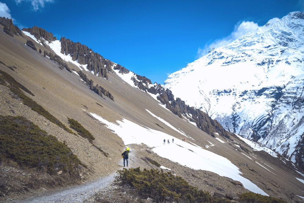 a group of people hiking up a snow covered mountain