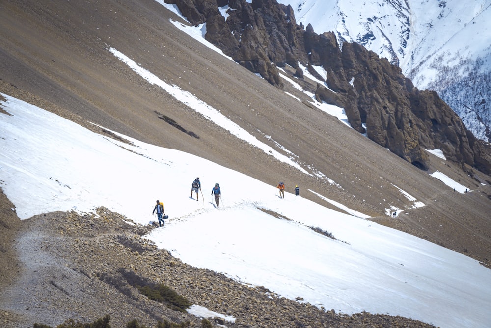 a group of people hiking up a snow covered mountain