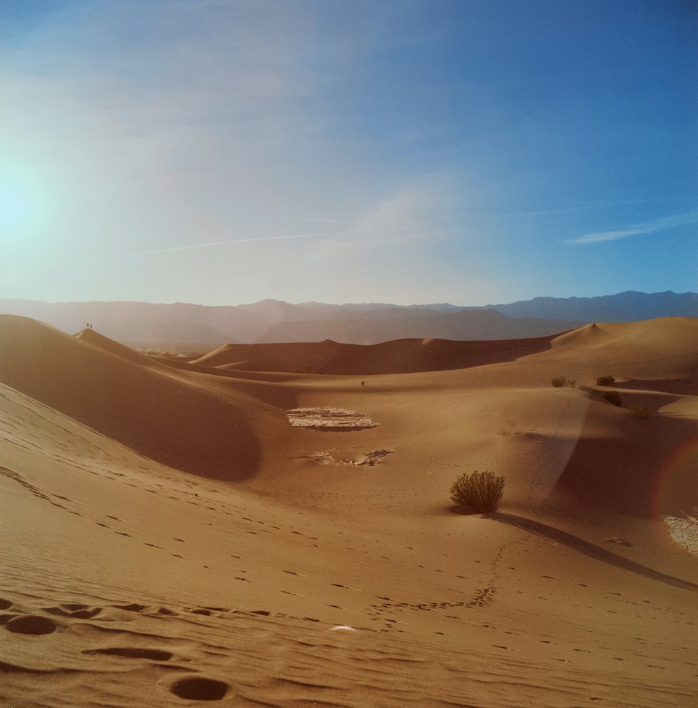 the sun is shining over a desert landscape