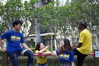 A diverse group of people wearing colorful graphic tees in an urban park setting, enjoying their time together.