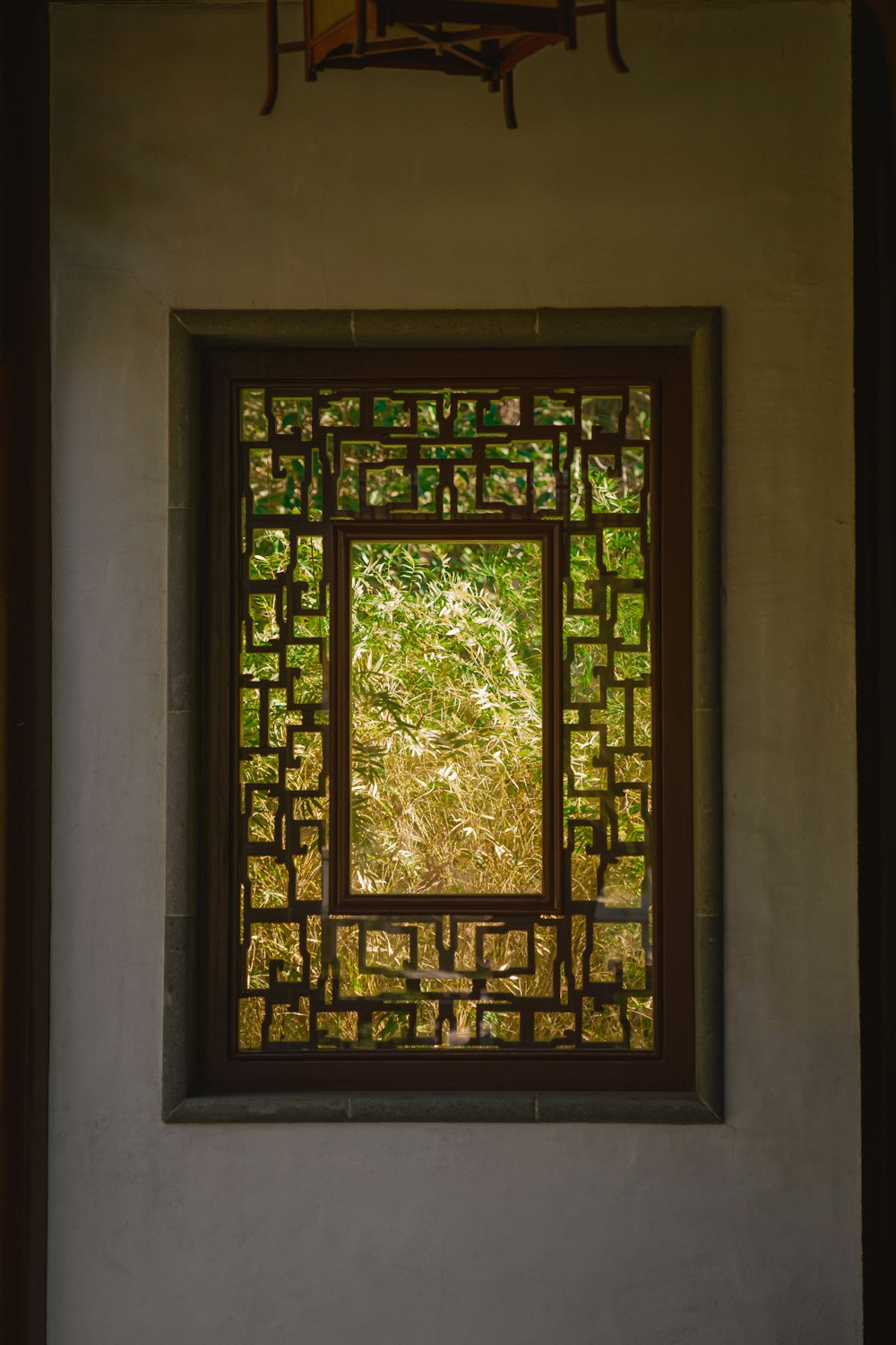 a window in a wall with a tree in the background