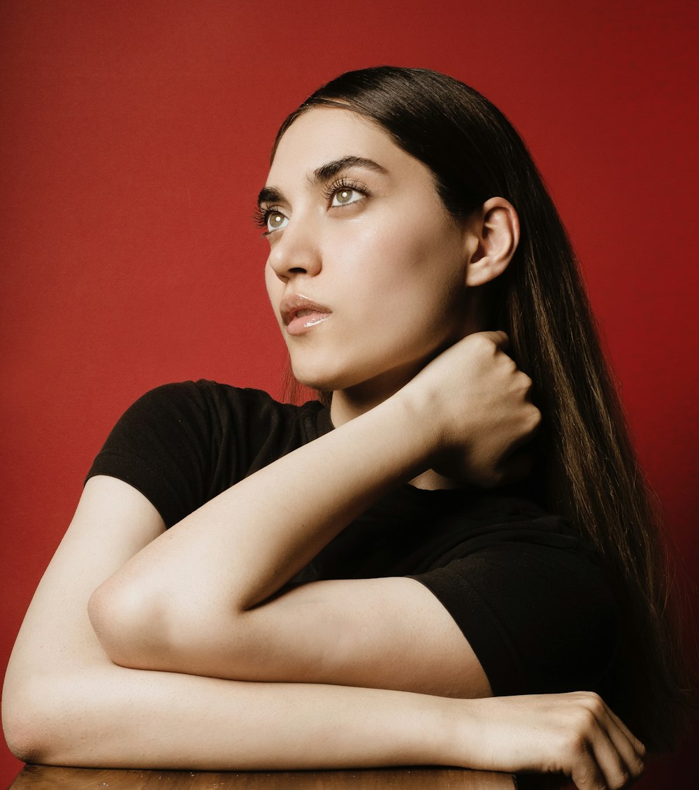 a woman sitting at a table with her arms crossed