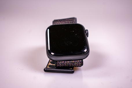 Close-up of a sleek black fitness watch against a matte black background highlighting luxury fitness gear.