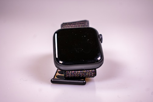 Close-up of a sleek, minimal wearable device prototype on a black surface.