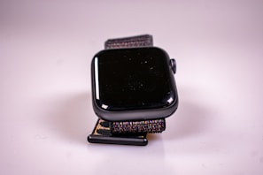 Close-up of a sleek black and gold smartwatch glowing softly on a wrist.