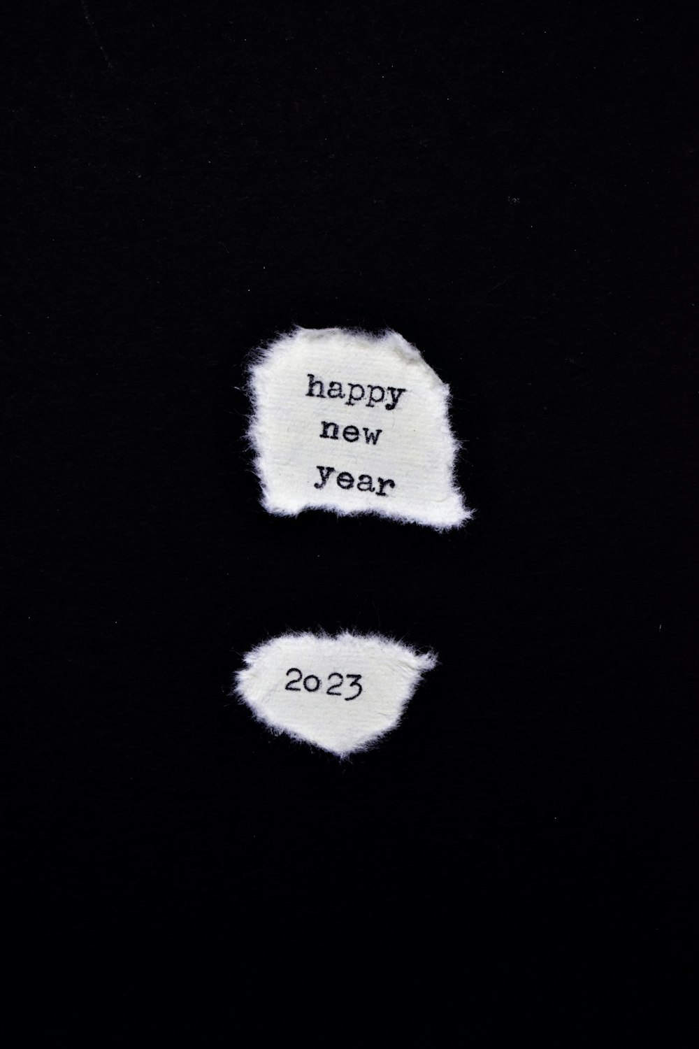 Due pezzi di carta con le parole Happy New Year scritte su di essi