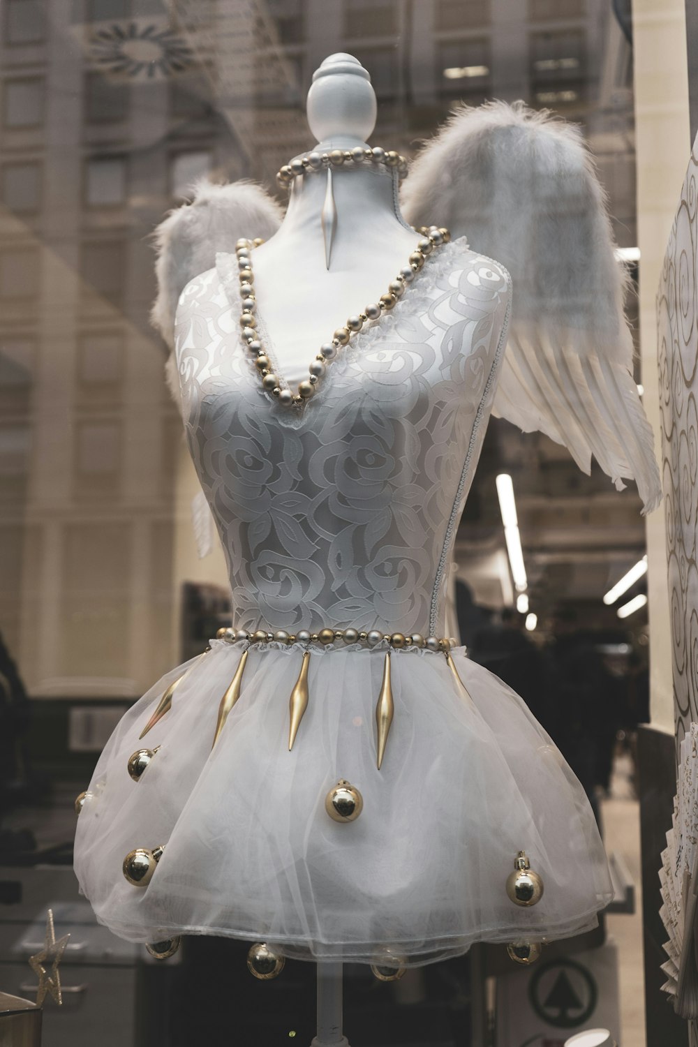 a mannequin dressed in a white dress with angel wings