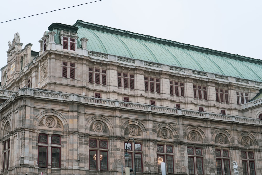 a large building with a green roof and a clock