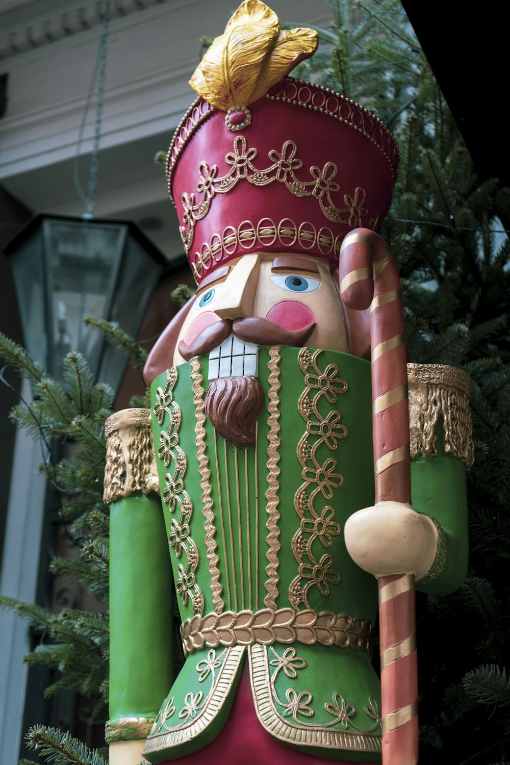 a large nutcracker statue sitting next to a christmas tree