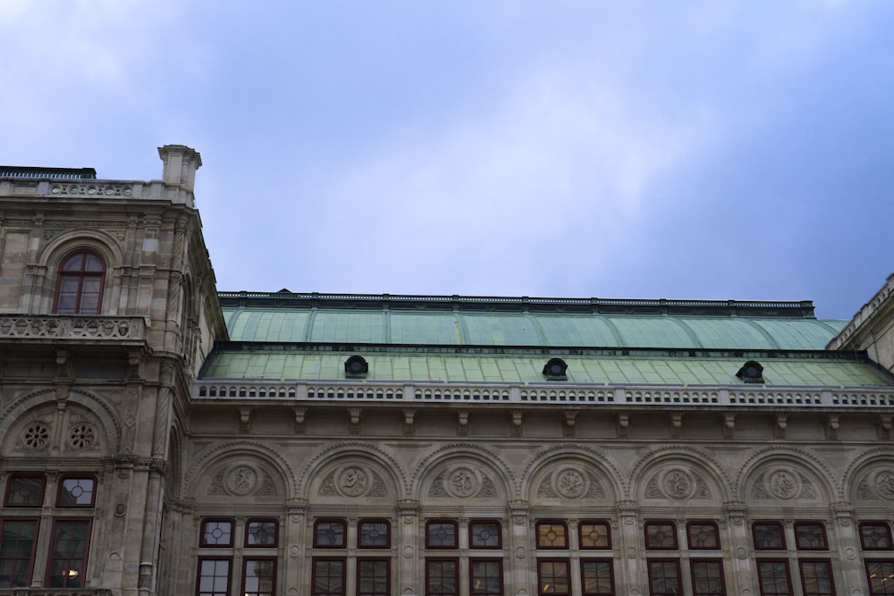 a very tall building with a green roof