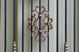 Close-up of a sturdy metal gate with intricate wrought iron details under natural light.