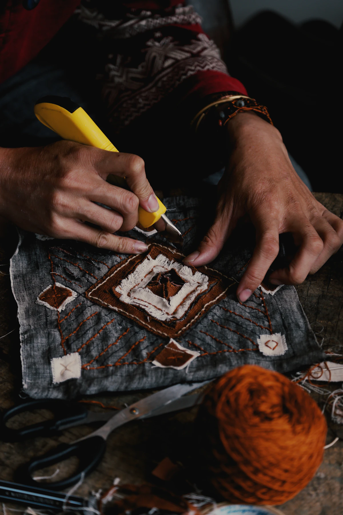 Mains d'artisan travaillant un morceau de tissu