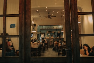 Warm, cozy coffee shop interior with customers enjoying conversations.