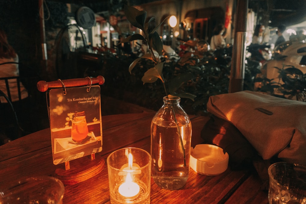 a wooden table topped with candles and bottles