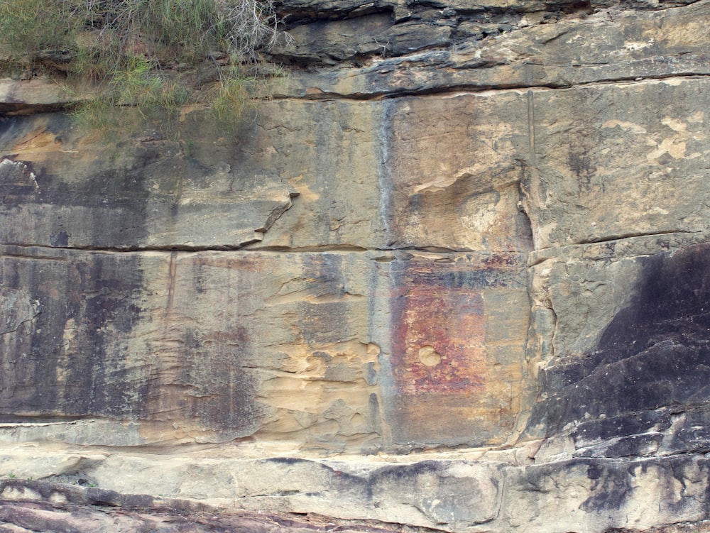 a rock wall with a painting on it