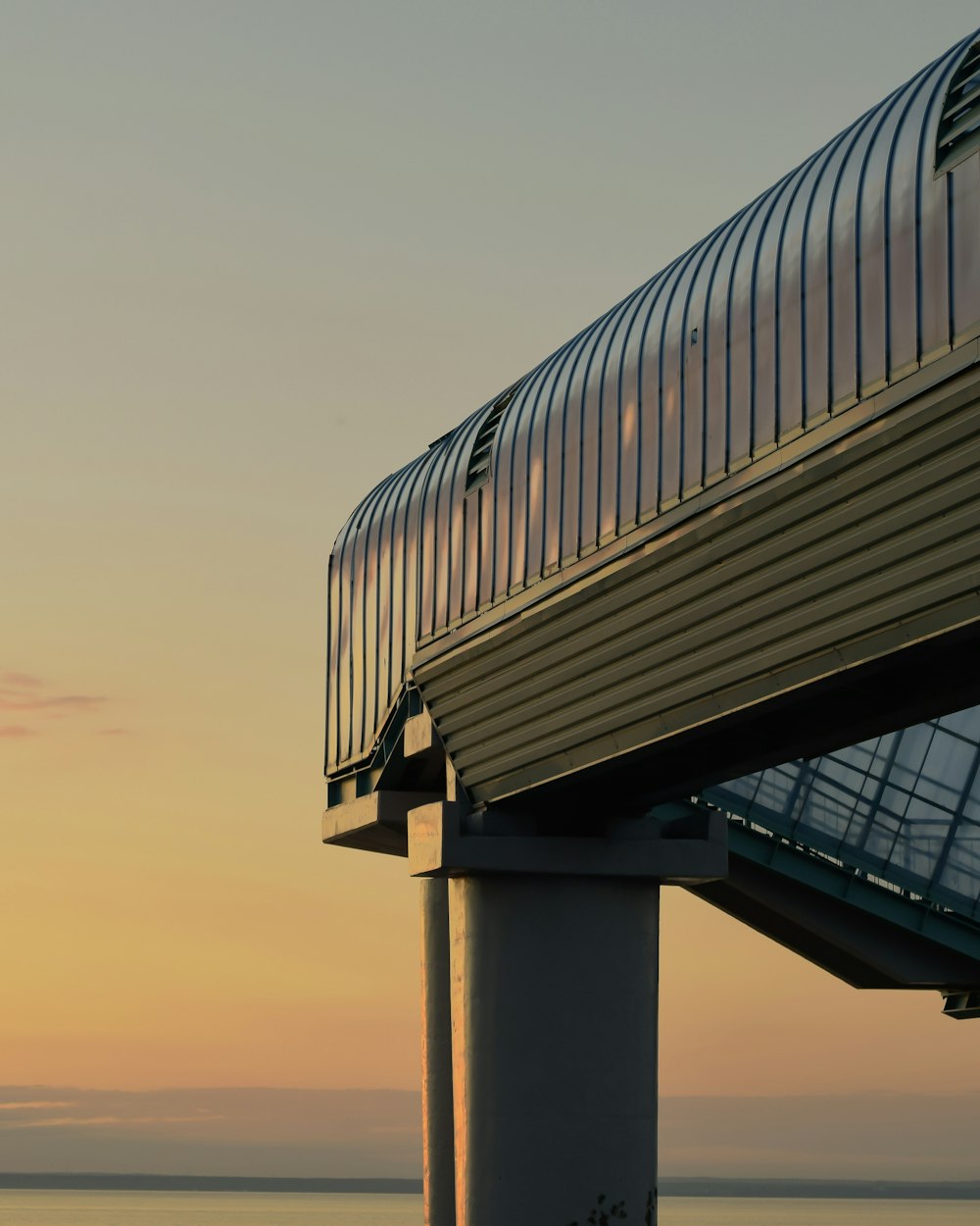 a view of a bridge over the water at sunset