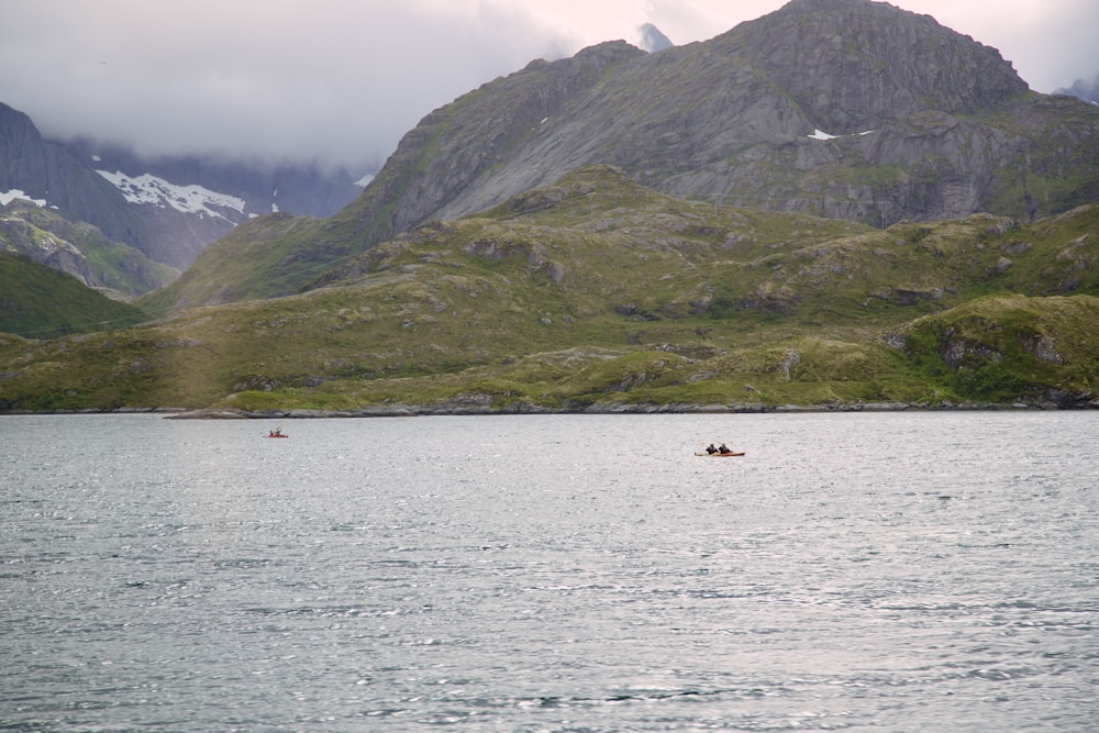 a couple of people in a small boat on a large body of water