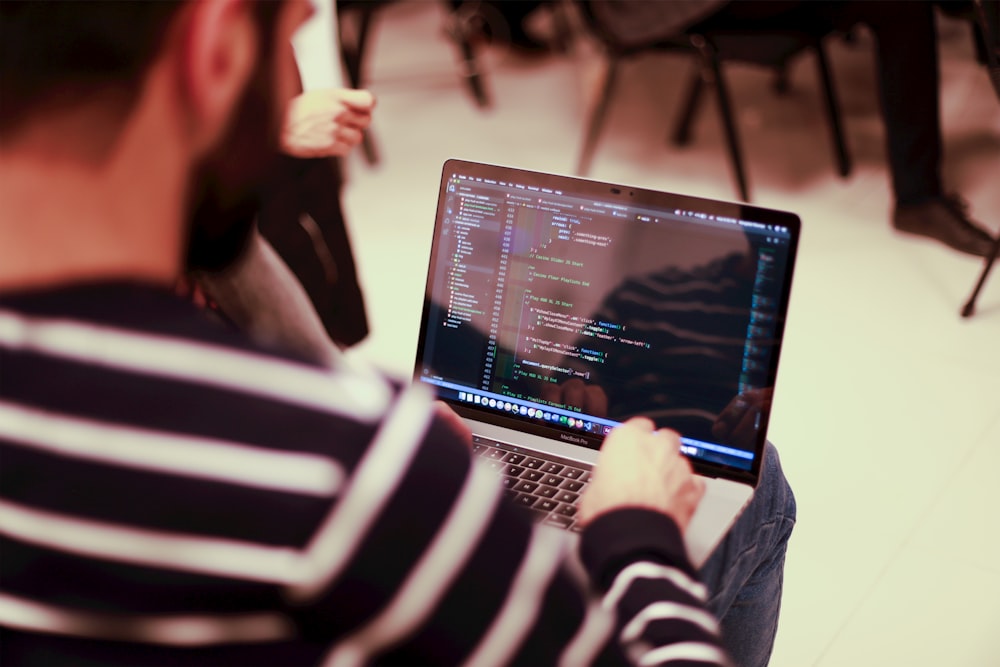 Un hombre sentado frente a una computadora portátil